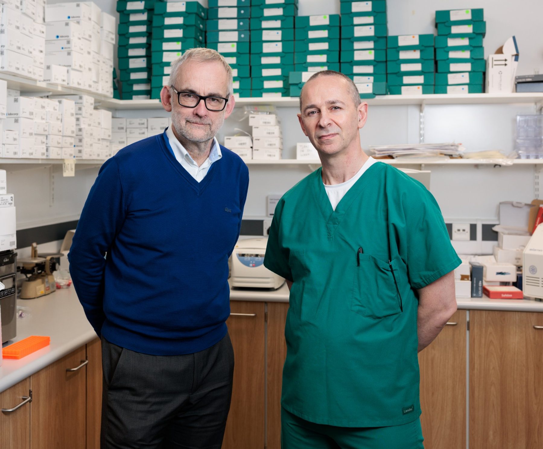 Professor Chris Probert and Dr Seamus Coyle standing in the laboratory in front of shelves of stored sample boxes